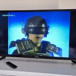 Szene aus der Science-Fiction-Serie Captain Power auf einem Fernseher mit futuristisch gekleideter Figur und blauem Hintergrund.